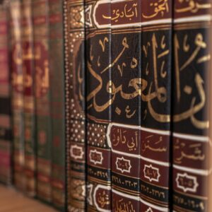 A bookshelf displays several antique, arabic-script books.